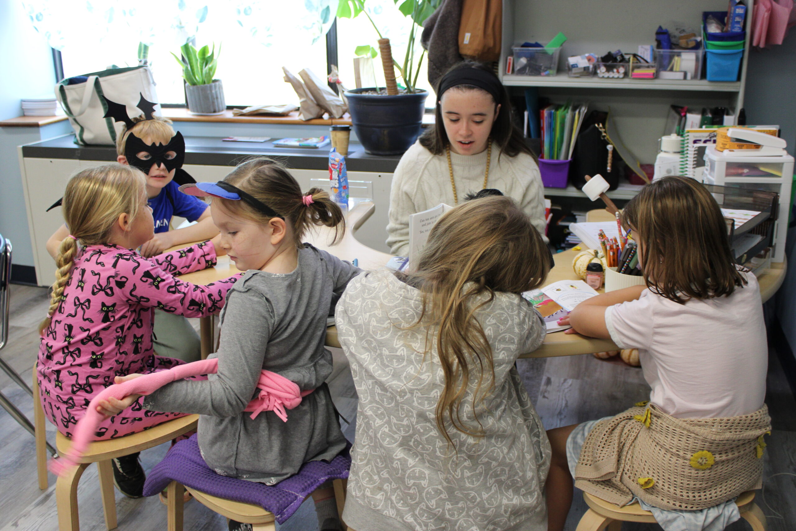 Young Grace students gathered around a classroom table
