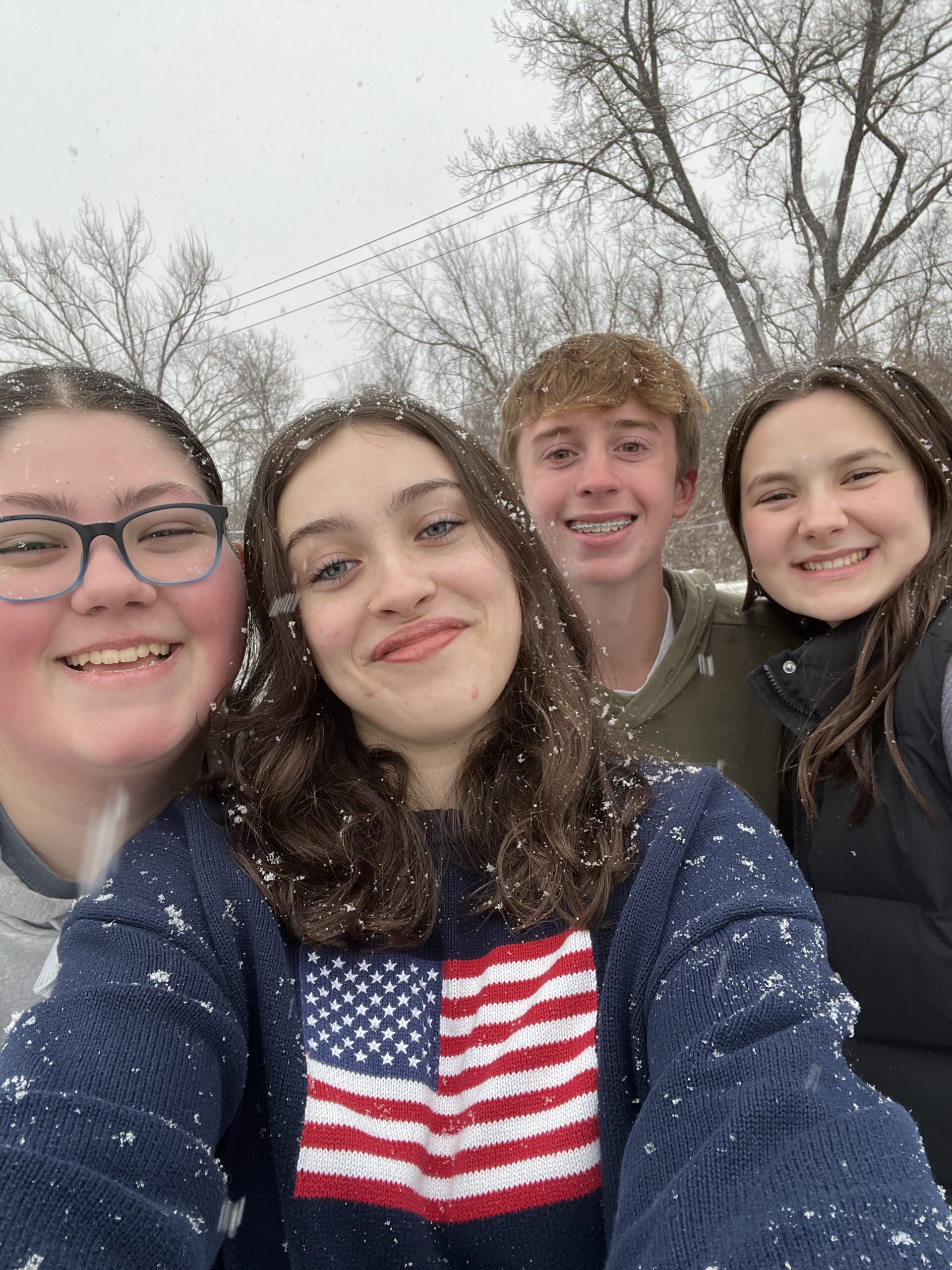 Four Grace students smiling together outdoors in the snow