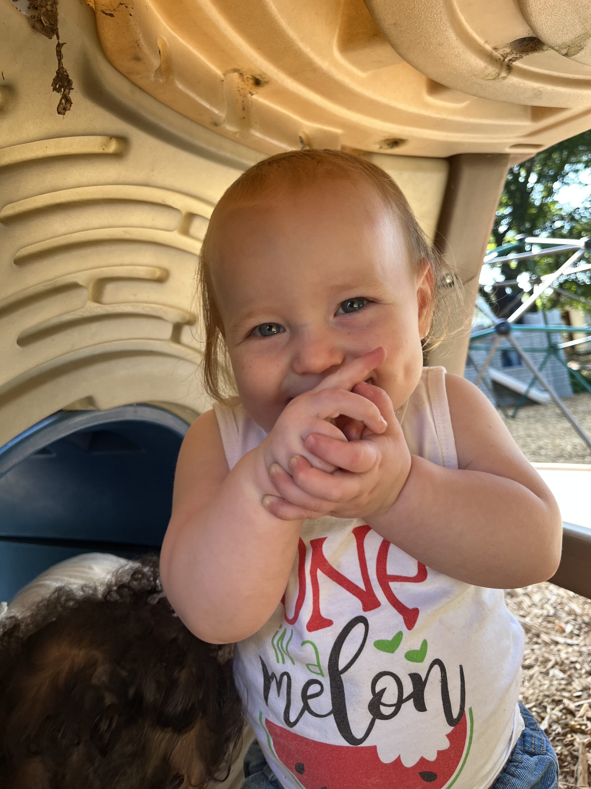 A smiling young child playing outdoors