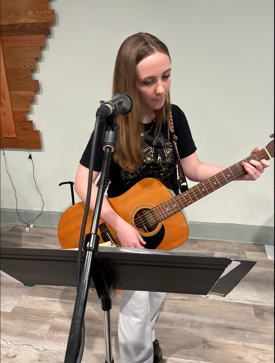 Grace Christian School student playing guitar and singing