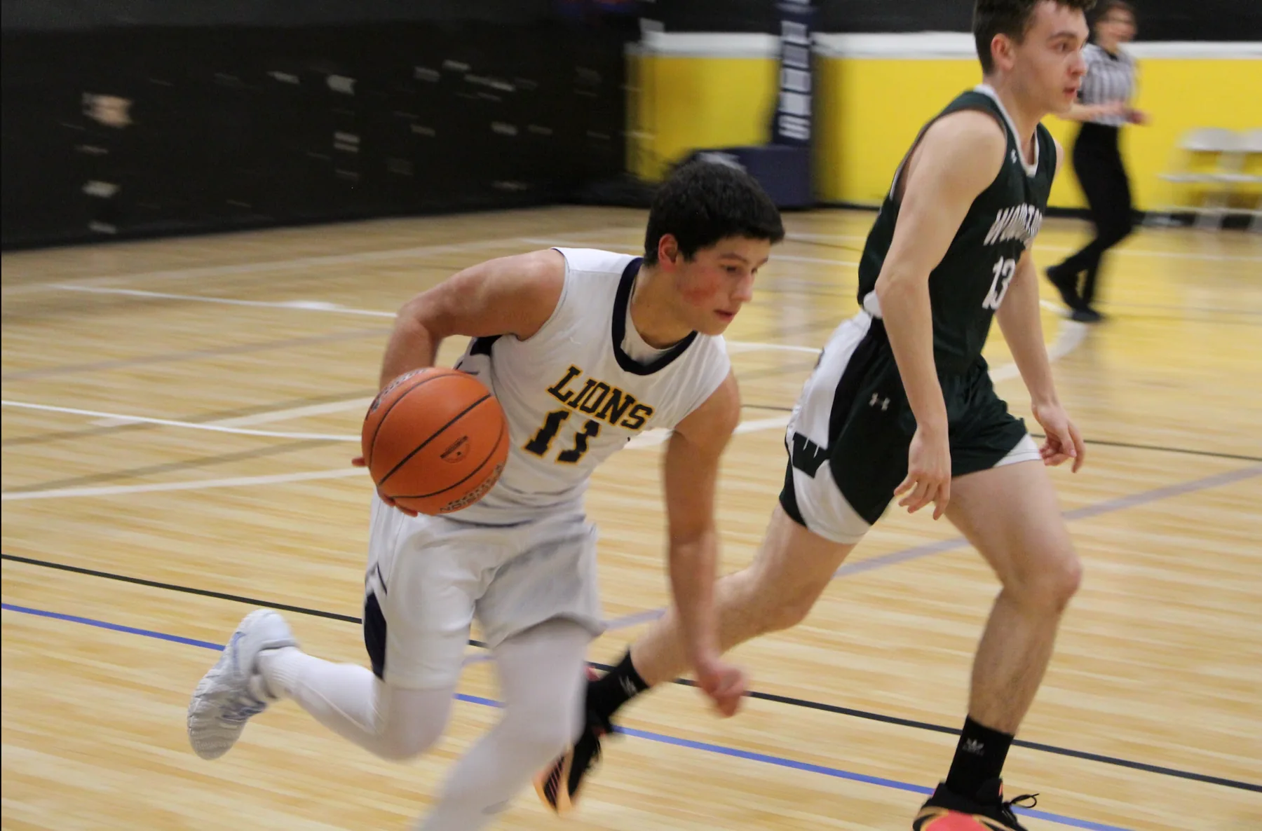 Grace Lions basketball player driving down the court