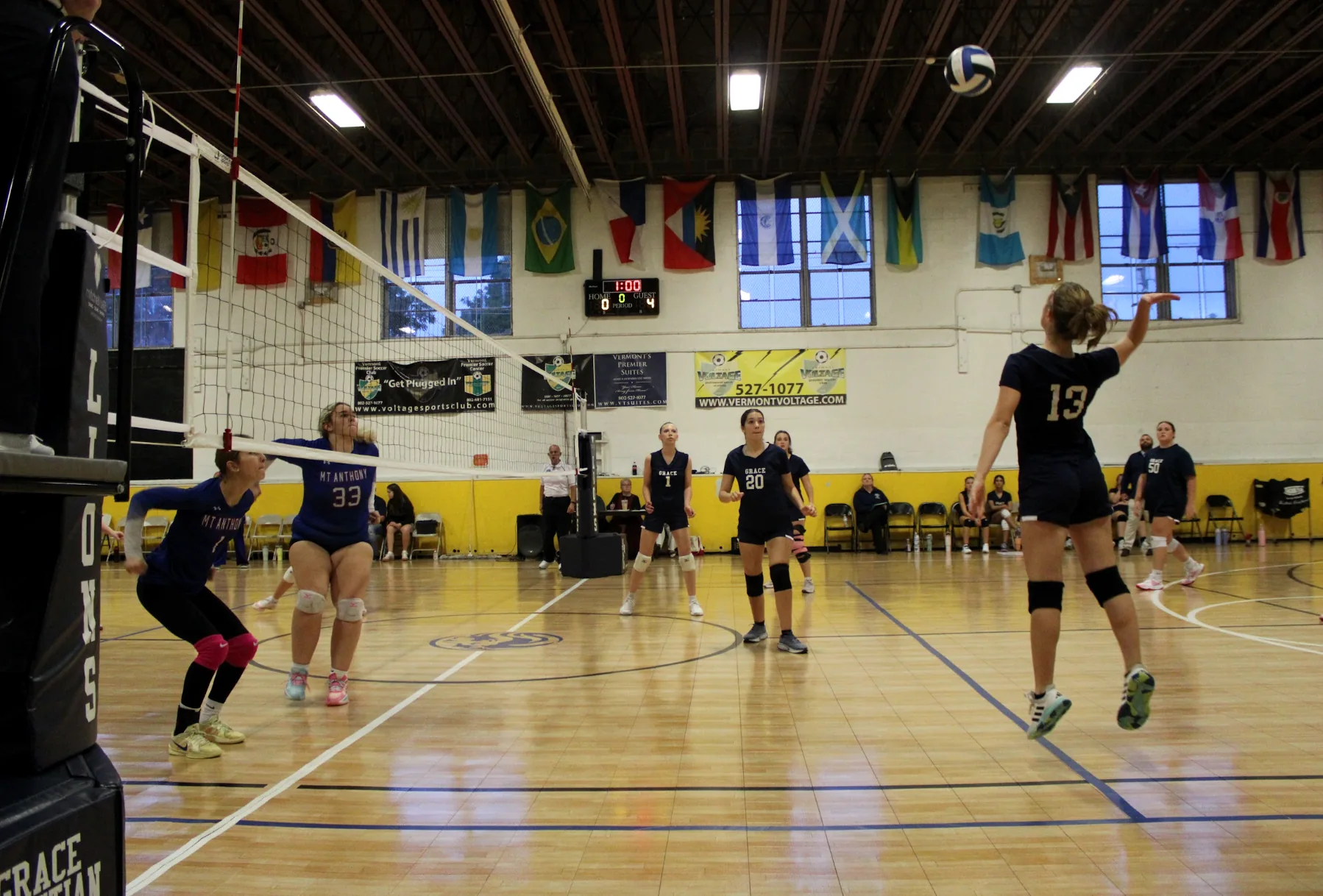 Grace Lions volleyball players competing at the net